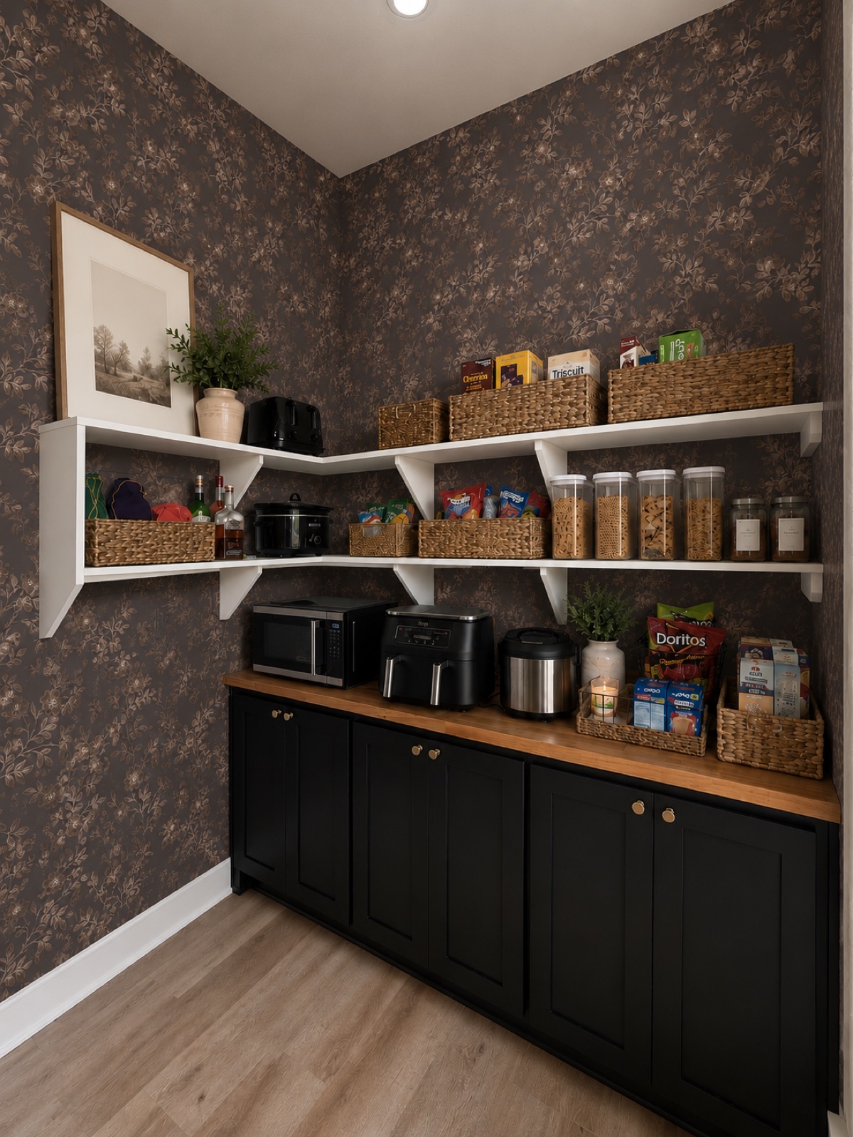 Dark floral wallpaper pantry with black cabinets and butcher block